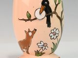 une petite tasse sur laquelle sont représentés un oiseau et un chien