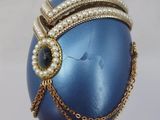 a blue egg with a chain around it on a stand