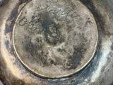 a silver tea pot with writing on it on a table