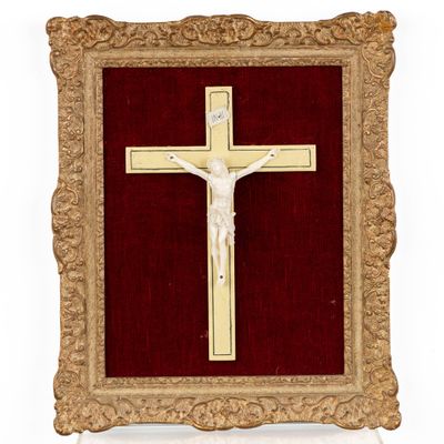 a gold framed crucifix with a red velvet background