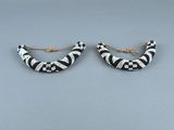 une paire de boucles d'oreilles en anneau rayées noir et blanc sur fond gris