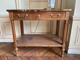 une table en bois avec un plateau en marbre posée sur un parquet en bois massif