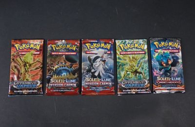 Quatre paquets de cartes à collectionner Pokémon sont alignés sur une table