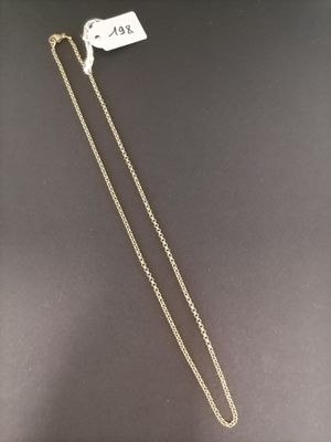 a gold necklace with a white diamond on a black background
