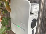 a white electronic device attached to the side of a wooden fence