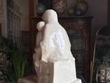 a statue of a woman sitting on top of a table