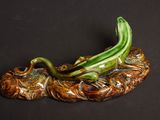 une figurine représentant un dragon posé sur un rocher, sur fond noir