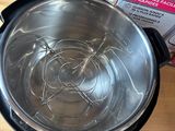 a silver bowl sitting on a wooden table next to a package of instant milk