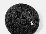 un chapeau noir orné de fleurs sur un fond blanc