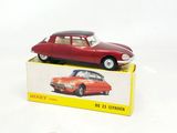 une petite voiture rouge posée sur une boîte
