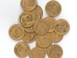 a pile of gold coins on a white surface