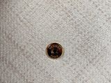 the back of a white and brown purse with a button on it