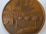 une pièce de monnaie en bronze sur laquelle est représentée une voiture