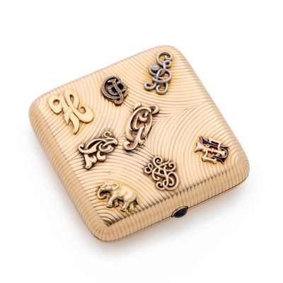 a small gold box with a lot of charms on it