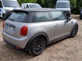 a silver mini cooper parked in a lot with other mini coopers