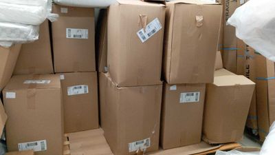 de nombreux cartons empilés les uns sur les autres dans un entrepôt