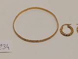 un gros plan sur un bracelet en or et une paire de boucles d'oreilles créoles