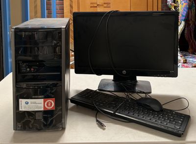 un ordinateur de bureau posé sur une table à côté d'un clavier et d'une souris