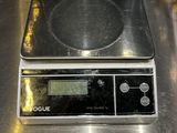 une balance numérique posée sur un comptoir en métal