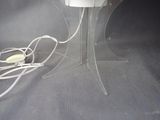 a table with a lamp and a remote on top of it