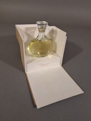 un flacon de parfum posé dans une boîte sur une table