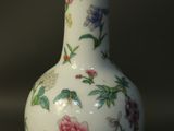 a white vase with flowers on it on a table
