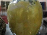 un vase jaune posé sur une table en verre dans une pièce