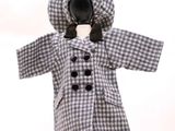une poupée vêtue d'un manteau et d'un chapeau