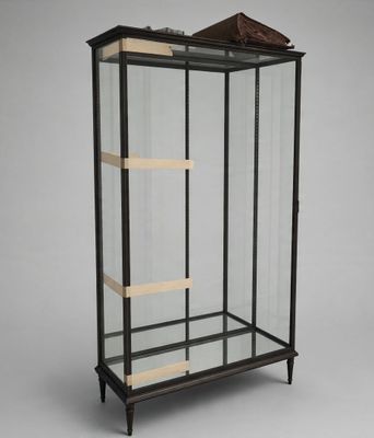 a black and gold display case with a bird on top of it