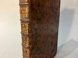 an old book with writing on it sitting on a white surface
