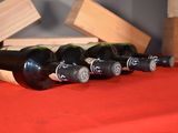 several bottles of wine are lined up on a red table