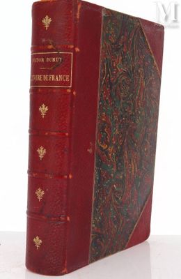 an old book sitting on top of a white table next to a clock