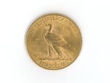 a gold coin with a bird on it on a white surface