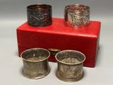 two silver cups and a red box on a white surface