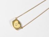 an image of a gold necklace with a picture of a woman on it