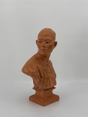 un petit buste d'homme en argile sur fond blanc