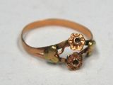 a gold ring with a flower design on it