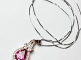 collier avec une pierre rose et une chaîne en argent sur fond blanc