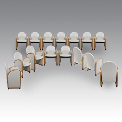 a group of white chairs with wooden legs and white cushions