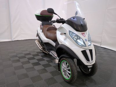 a motor scooter that is parked on a black and white checkered floor