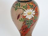 a glass vase with a flower on it on a white background