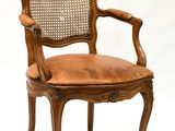 une image représentant une chaise en bois avec une assise en cuir marron