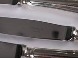 three knives and a knife holder on a table