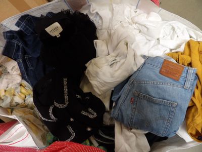 a suitcase full of clothes and clothes sitting on the floor