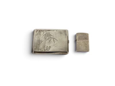 un vieux étui à cigarettes en argent posé à côté d'un briquet sur une surface blanche