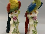 paire de perroquets en céramique colorés, perchés sur une branche ornée de roses