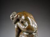 a bronze statue of a man with his head in his hands