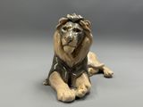a figurine of a lion laying down on the ground