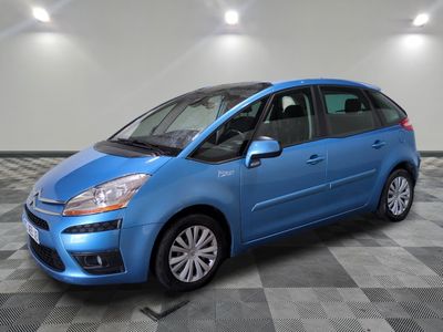 une voiture bleue est garée dans une pièce au sol à carreaux