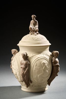 un vase blanc surmonté d'une statue